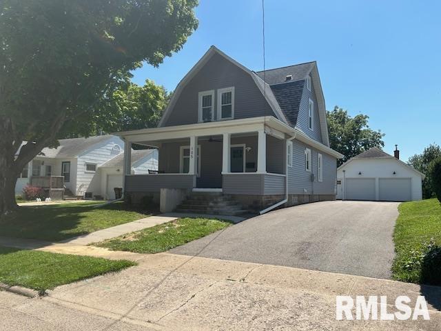 bungalow with a garage, covered porch, an outbuilding, and a front yard