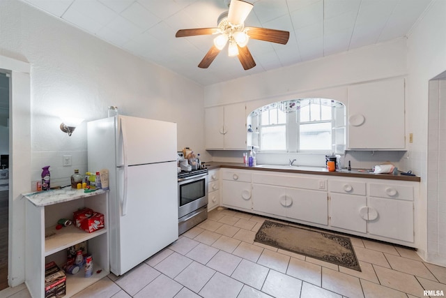 kitchen featuring white cabinetry, stainless steel electric range, light tile patterned flooring, and white refrigerator