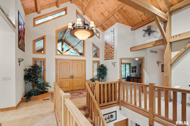 foyer with wooden ceiling, an inviting chandelier, beam ceiling, and high vaulted ceiling