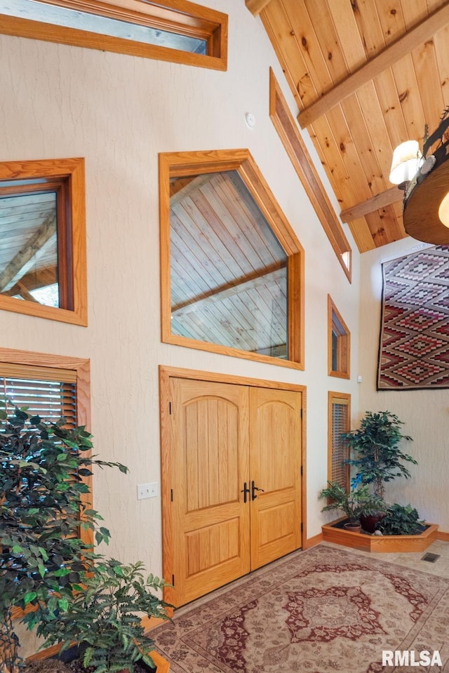 interior space featuring wooden ceiling, beam ceiling, and high vaulted ceiling