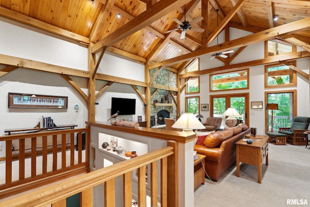 carpeted living room with a fireplace, beam ceiling, high vaulted ceiling, and wood ceiling