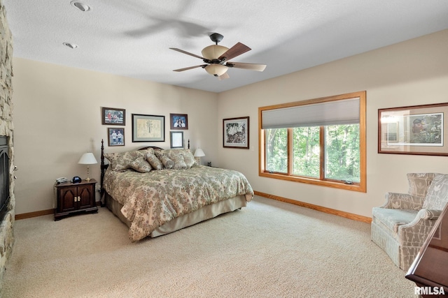 carpeted bedroom featuring a textured ceiling and ceiling fan