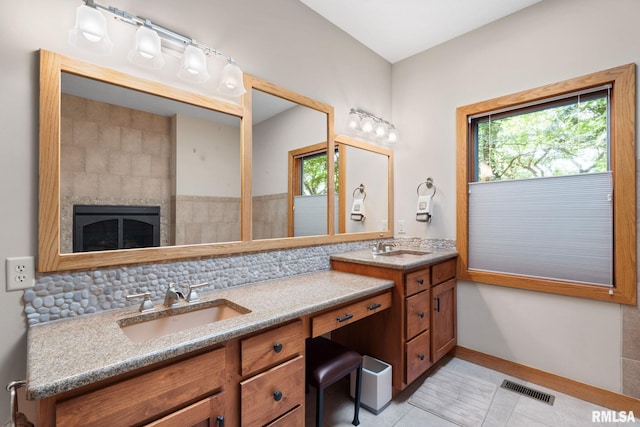 bathroom featuring vanity, tile patterned floors, decorative backsplash, and a wealth of natural light