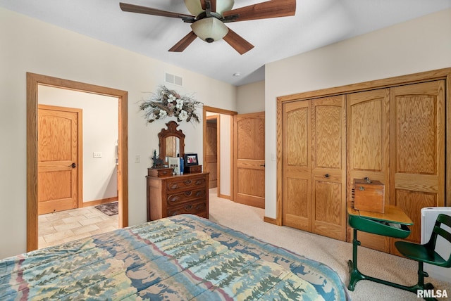 bedroom featuring light colored carpet, a closet, and ceiling fan