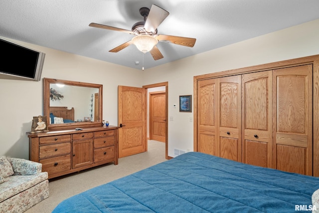 carpeted bedroom featuring a closet and ceiling fan