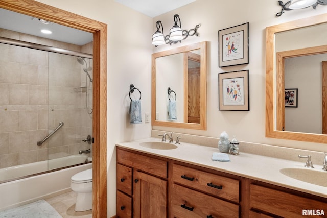 full bathroom with dual vanity, toilet, tile patterned floors, and bath / shower combo with glass door