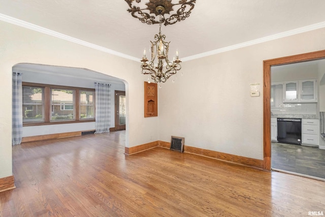 spare room featuring crown molding, a chandelier, and hardwood / wood-style floors