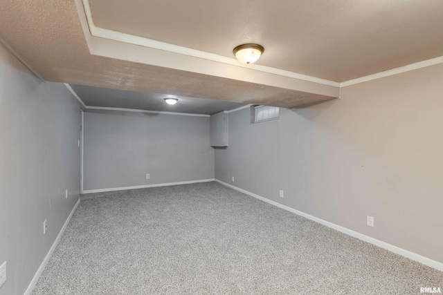 basement with carpet floors, a textured ceiling, and ornamental molding