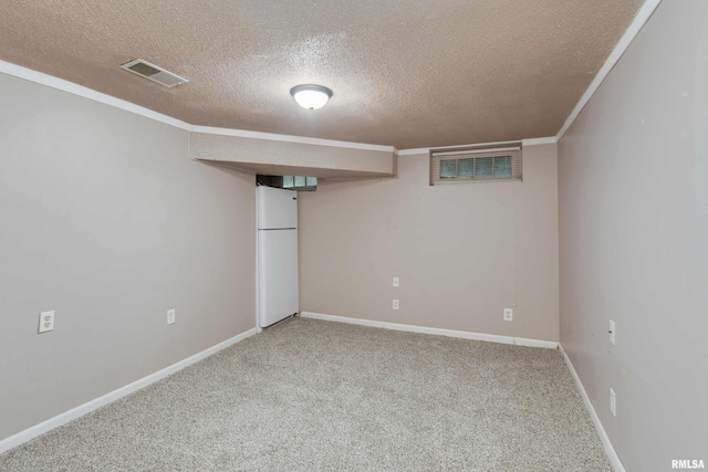 basement with crown molding, white fridge, carpet, and a textured ceiling