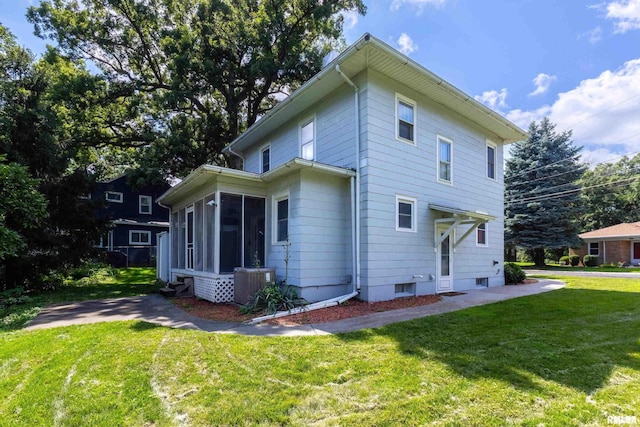 rear view of property featuring a yard, a sunroom, and central AC unit