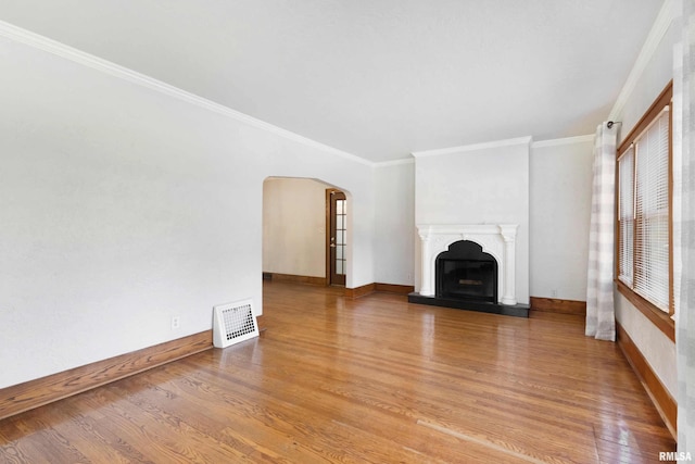 unfurnished living room with wood-type flooring and crown molding