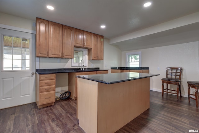 kitchen featuring sink, a kitchen island, and dark hardwood / wood-style flooring