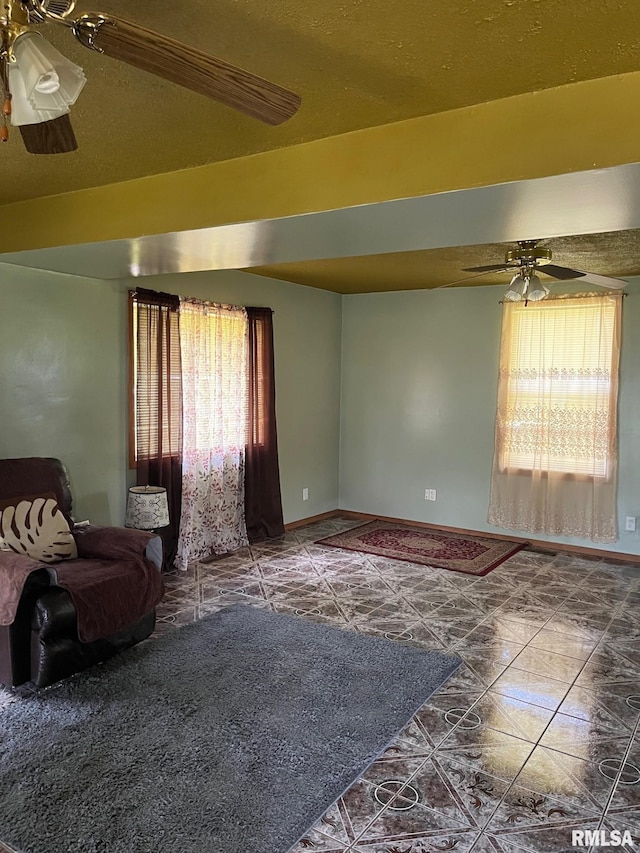 empty room with ceiling fan, a textured ceiling, and tile patterned flooring