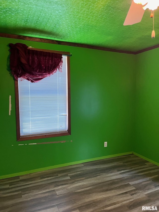 spare room featuring a textured ceiling, ornamental molding, and hardwood / wood-style floors