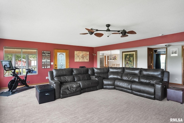 living area featuring ceiling fan, a textured ceiling, carpet flooring, and baseboards