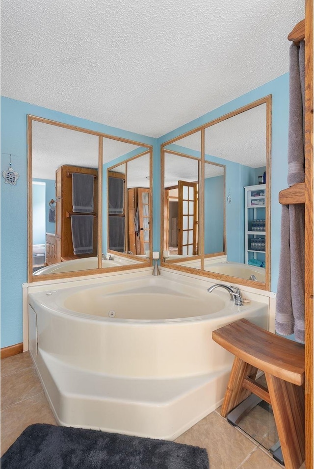 full bathroom featuring a bath, tile patterned flooring, and a textured ceiling