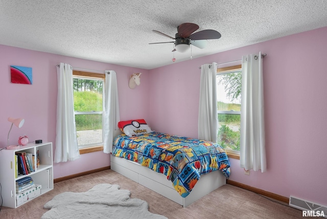 bedroom with multiple windows, visible vents, and a textured ceiling