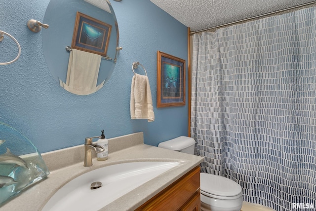 bathroom with a textured wall, toilet, curtained shower, a textured ceiling, and vanity