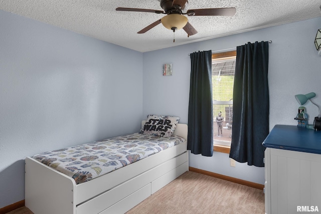 bedroom featuring a textured ceiling, ceiling fan, light carpet, and baseboards