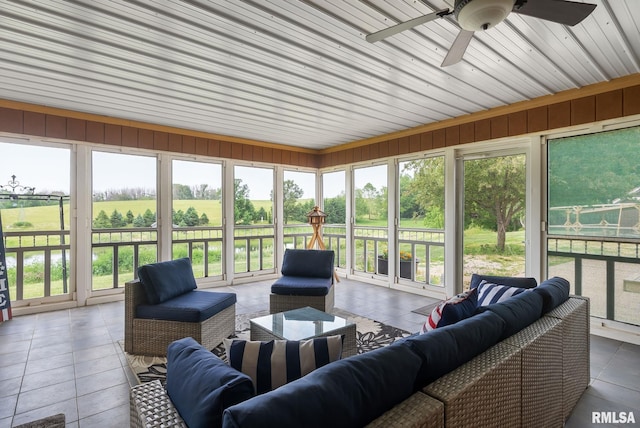 sunroom / solarium featuring ceiling fan and a rural view