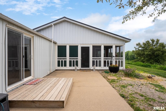 rear view of property featuring a sunroom and a patio area