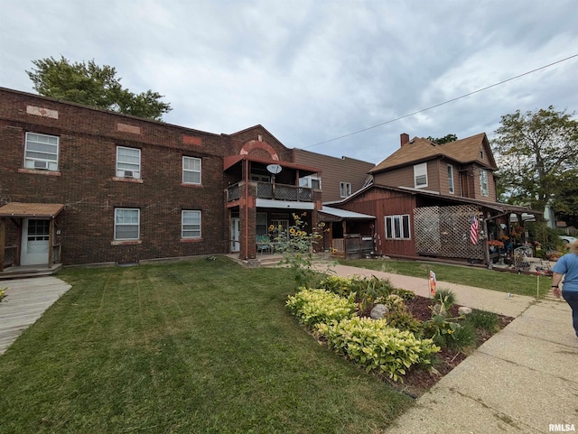 view of front of property with a balcony and a front yard