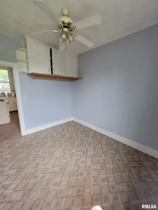 empty room featuring carpet flooring, baseboards, and ceiling fan