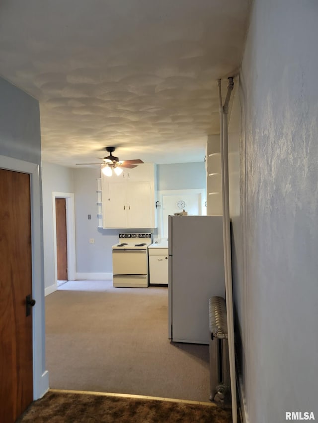 interior space featuring ceiling fan, white electric range oven, fridge, light carpet, and white cabinetry