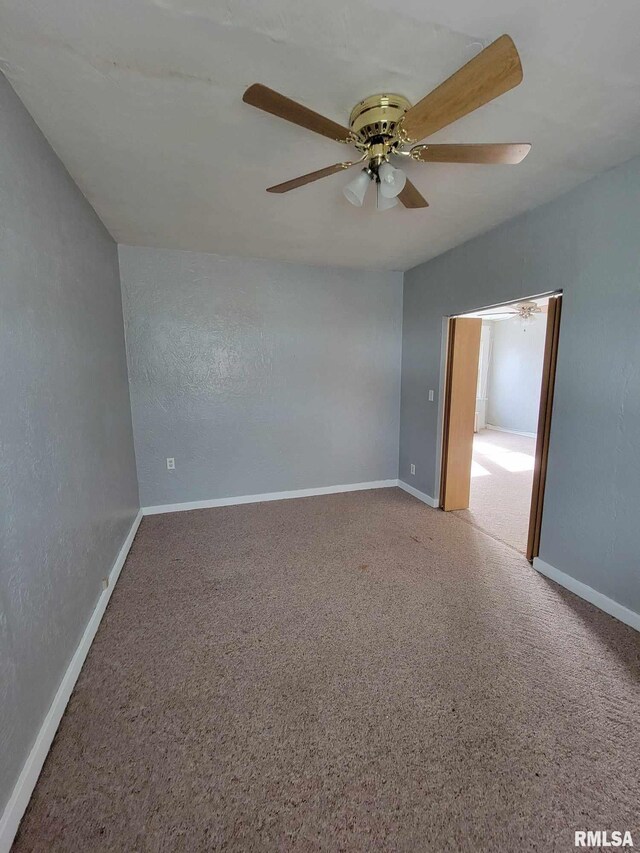 carpeted empty room featuring ceiling fan