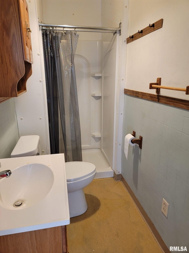 bathroom featuring toilet, tile walls, curtained shower, and vanity