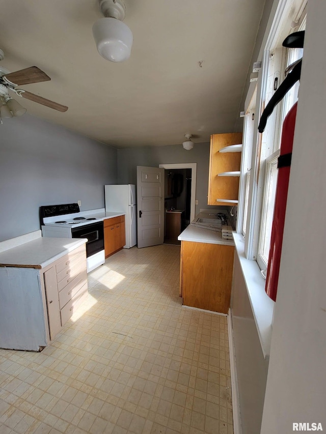 kitchen featuring light floors, brown cabinets, range with electric stovetop, freestanding refrigerator, and open shelves