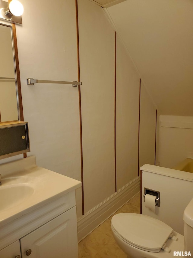 bathroom featuring tile patterned flooring, toilet, vanity, and lofted ceiling