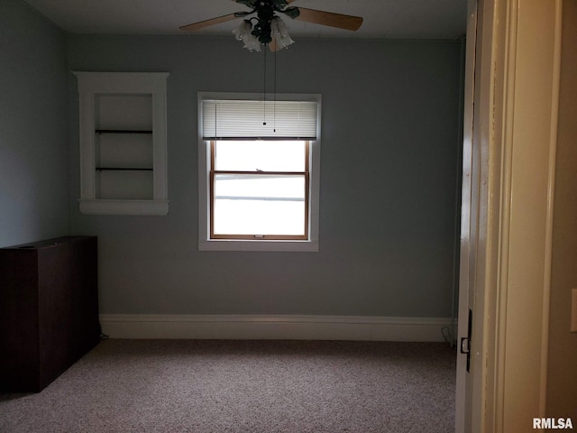 carpeted spare room featuring ceiling fan