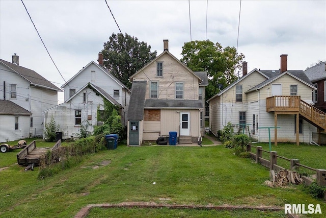 rear view of property featuring a yard and a deck