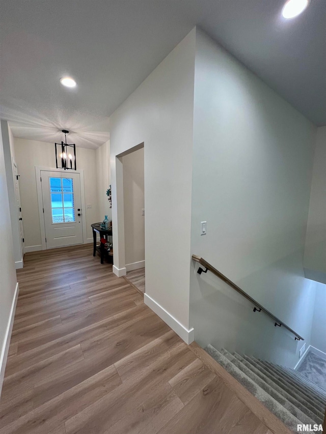 hall featuring a notable chandelier and light wood-type flooring