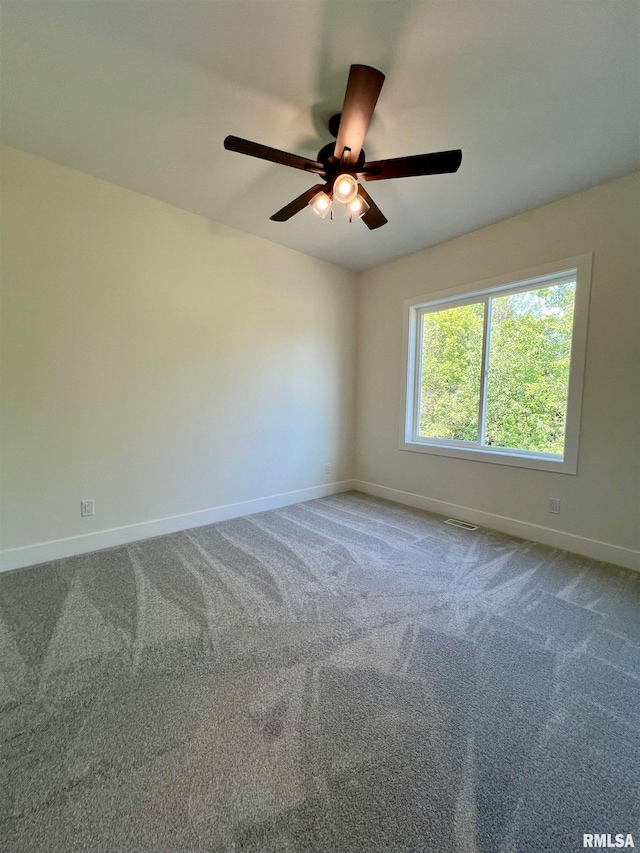 carpeted spare room with ceiling fan