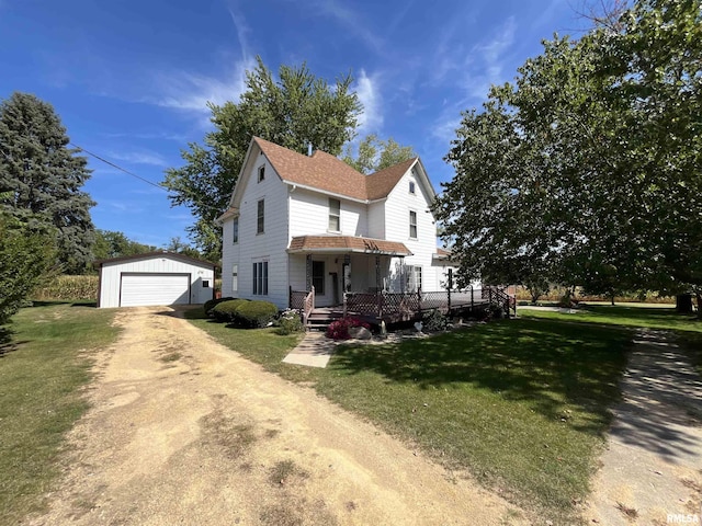 view of front of home with a garage, an outbuilding, and a front yard