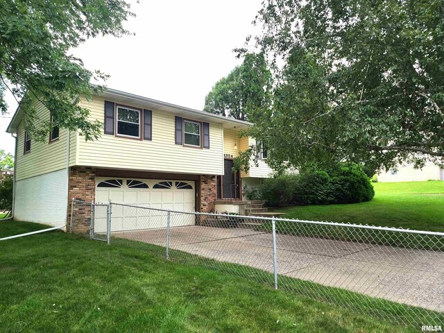 split foyer home featuring a garage and a front lawn