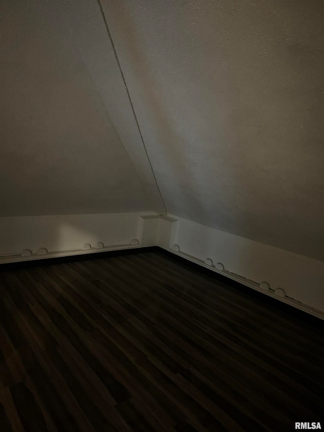 bonus room featuring vaulted ceiling and dark hardwood / wood-style flooring