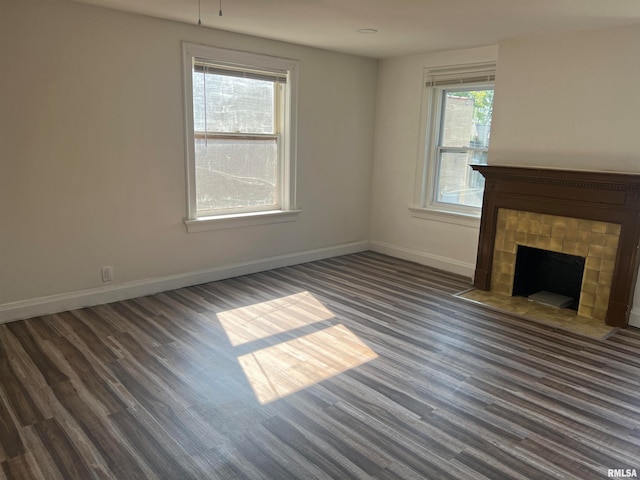 unfurnished living room featuring a fireplace and dark wood-type flooring