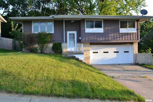 split foyer home featuring a front lawn and a garage