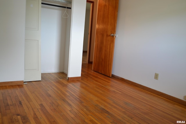 unfurnished bedroom with a closet and hardwood / wood-style floors