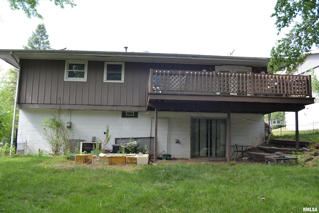 back of property featuring a wooden deck and a yard