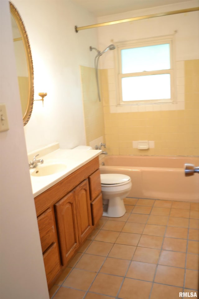 full bathroom featuring toilet, tiled shower / bath, vanity, and tile patterned flooring