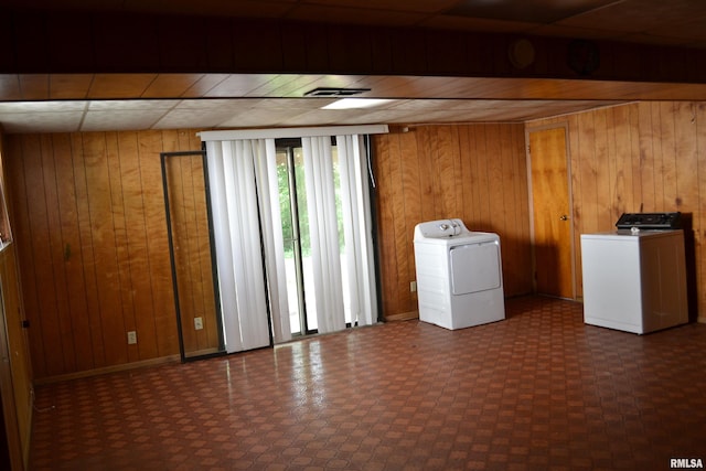 washroom featuring washer and dryer and wooden walls