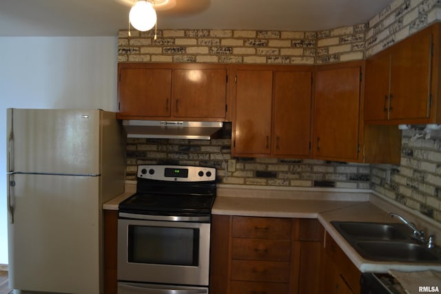 kitchen featuring tasteful backsplash, stainless steel electric range, sink, and fridge