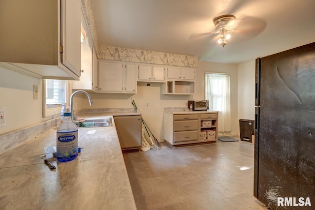 kitchen featuring sink, black refrigerator, ceiling fan, and stainless steel dishwasher