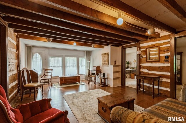 living area featuring beamed ceiling and dark hardwood / wood-style flooring