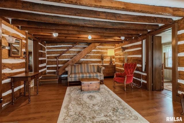 sitting room featuring beamed ceiling, dark hardwood / wood-style flooring, and rustic walls