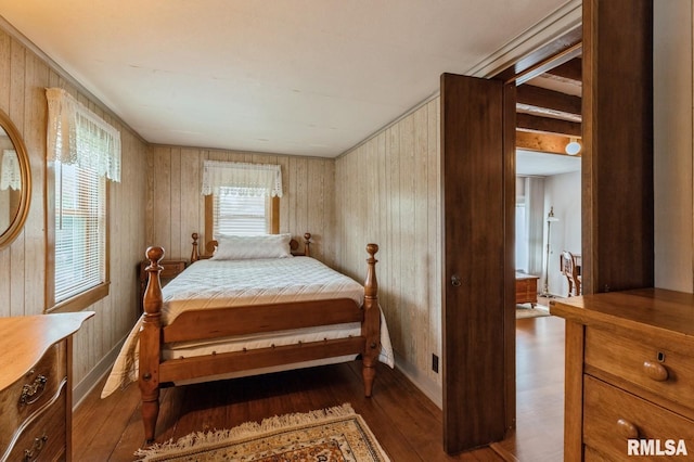 bedroom featuring dark wood-type flooring and wooden walls